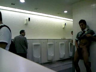 Guy jacks of in public restroom for audience